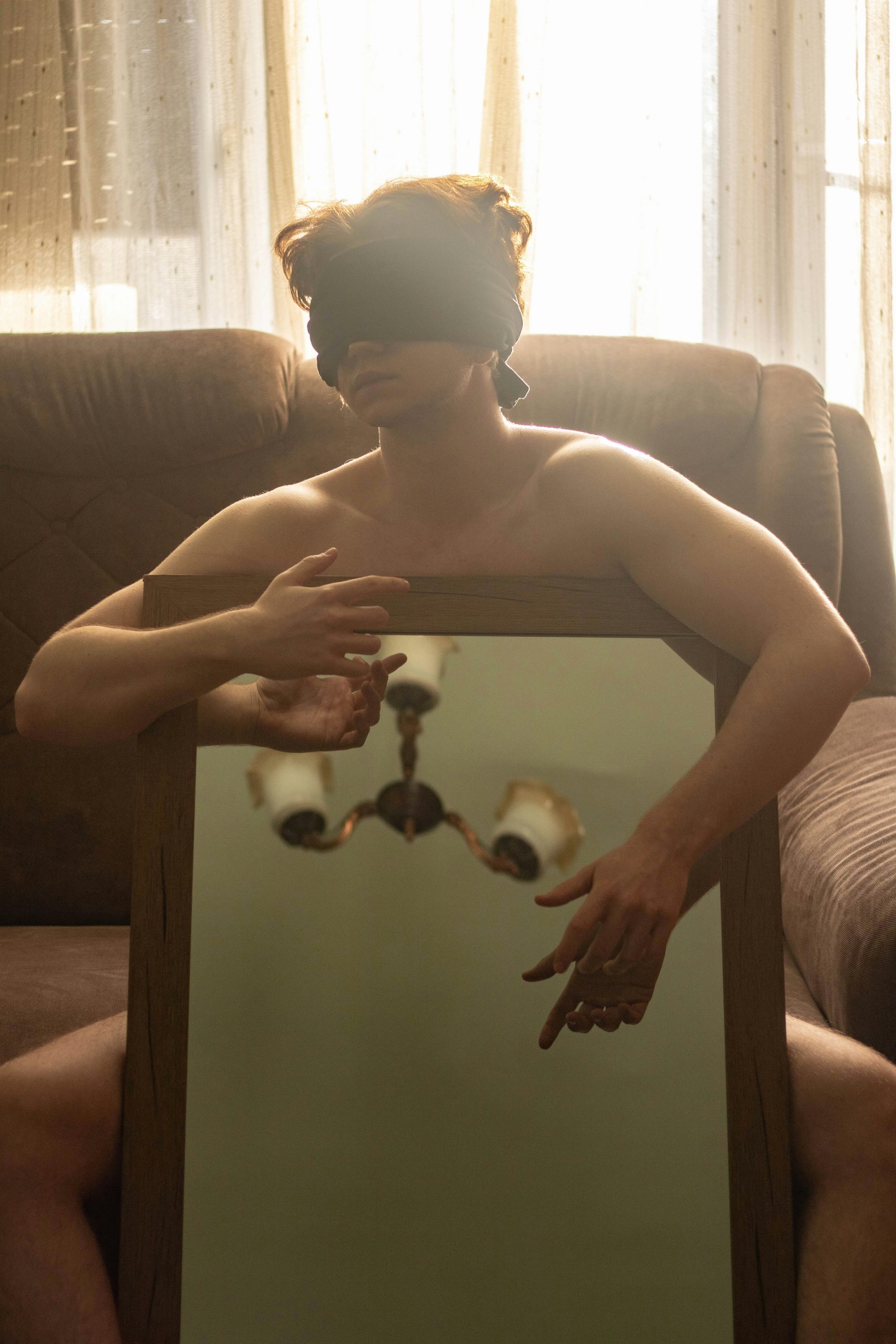 Person blindfolded holding a mirror — gaslighting and manipulation
